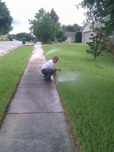 a Vallejo irrigation repair tech is adjusting a sprinkler head